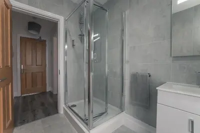 a shower with a glass door in a bathroom at Clarence Street Town House in Liverpool