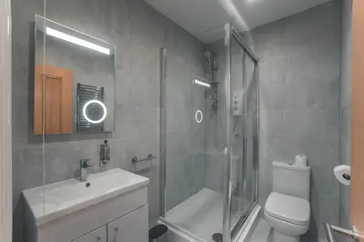 a bathroom with a shower and a toilet and a sink at Clarence Street Town House in Liverpool