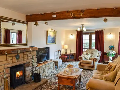 a living room with a fireplace and a tv at Priory Barn in Burscough