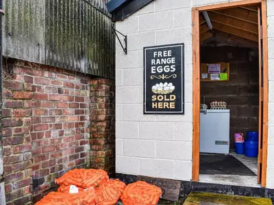 a sign on the side of a brick building with orange bags at Priory Barn in Burscough