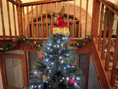 a christmas tree in front of a staircase at Priory Barn in Burscough