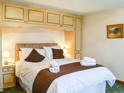 a bedroom with a large bed with towels on it at Priory Barn in Burscough