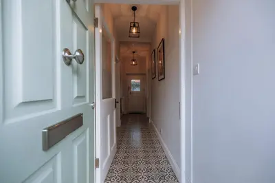 a hallway with a door and a tile floor at Church View Cottage in Whalley