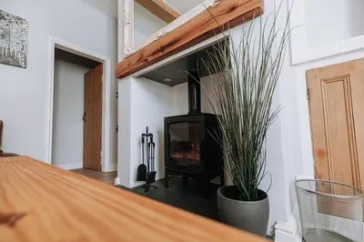 a living room with a wood stove in a room at Church View Cottage in Whalley