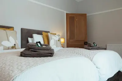 a bedroom with two beds with towels on them at Church View Cottage in Whalley