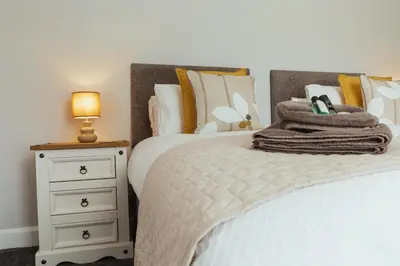 a bedroom with a bed and a night stand with a lamp at Church View Cottage in Whalley