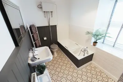 a bathroom with a sink and a bath tub at Church View Cottage in Whalley