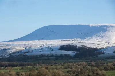 a snow covered mountain in the middle of a field at Church View Cottage in Whalley