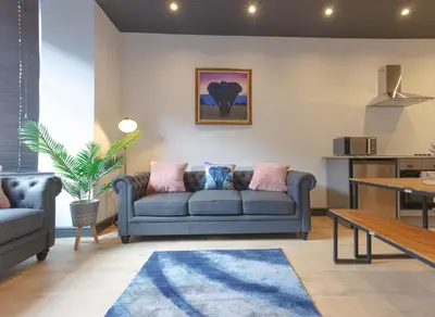 a living room with a blue couch and a table at No 10 Apartments in Blackpool