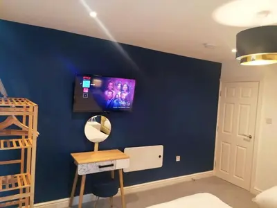 a room with a blue wall with a tv on it at No 10 Apartments in Blackpool