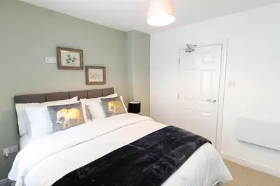 a bedroom with a bed with a black blanket on it at No 10 Apartments in Blackpool