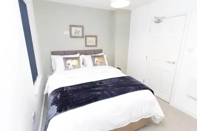 a bedroom with a bed with a black and white comforter at No 10 Apartments in Blackpool