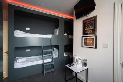 a room with two bunk beds and a table at The Breckfield Hotel in Liverpool