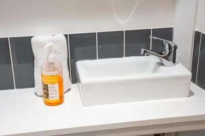 a bottle of soap sitting on a counter next to a sink at The Breckfield Hotel in Liverpool