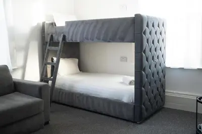 a bedroom with a bunk bed and a chair at The Breckfield Hotel in Liverpool