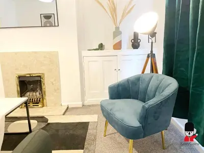 a living room with a blue chair and a fireplace at KozyGuru / Wigan / 2BR 4Beds / Newly Refurbished Stylish Holiday House / Close to Big Retail Park / UWNE034 in Wigan