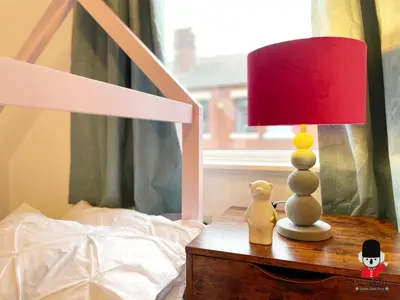 a lamp on a night stand next to a bed at KozyGuru / Wigan / 2BR 4Beds / Newly Refurbished Stylish Holiday House / Close to Big Retail Park / UWNE034 in Wigan