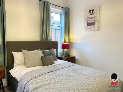 a bedroom with a white bed with a window at KozyGuru / Wigan / 2BR 4Beds / Newly Refurbished Stylish Holiday House / Close to Big Retail Park / UWNE034 in Wigan