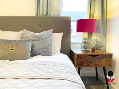 a bedroom with a bed with a red lamp on a night stand at KozyGuru / Wigan / 2BR 4Beds / Newly Refurbished Stylish Holiday House / Close to Big Retail Park / UWNE034 in Wigan
