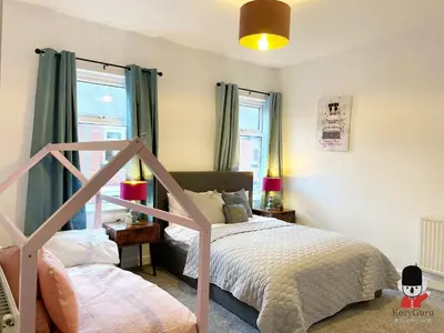 a bedroom with a bed and a window at KozyGuru / Wigan / 2BR 4Beds / Newly Refurbished Stylish Holiday House / Close to Big Retail Park / UWNE034 in Wigan