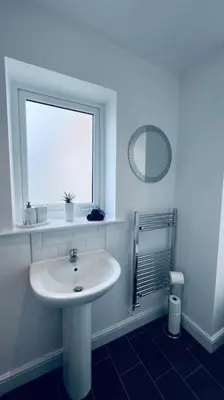 a white bathroom with a sink and a window at Contemporary studio apartment in Pemberton