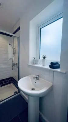 a white bathroom with a sink and a window at Contemporary studio apartment in Pemberton