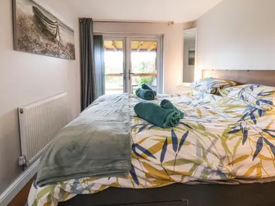 a bedroom with a large bed with two pillows on it at Meols Holiday Lodge in Wirral