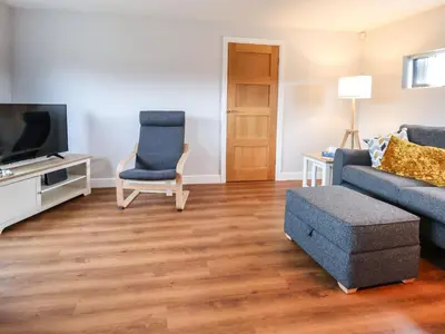 a living room with a couch and a tv at Meols Holiday Lodge in Wirral