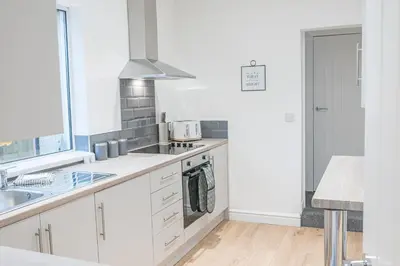 a white kitchen with a sink and a stove at 24 Baden Powell in Barrow in Furness