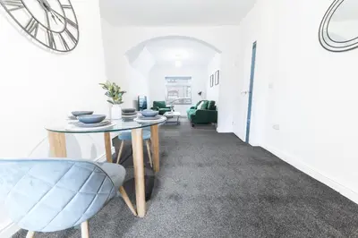 a dining room with a table and a blue chair at 24 Baden Powell in Barrow in Furness