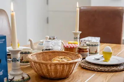 a table with candles and a basket of food on it at Finest Retreats - Middle Warble Stables in Mellor