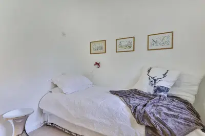 a white bedroom with a bed and two pictures on the wall at Finest Retreats - Middle Warble Stables in Mellor