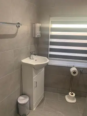 a white bathroom with a sink and a window at Bloomsbury House - Modern studios near Anfield in Liverpool