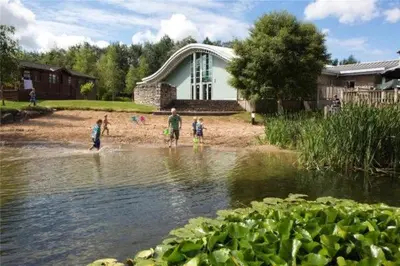 a group of people standing in the water near a pond at Borwick Lakes Holiday Caravan (Partial Lake View) in Borwick