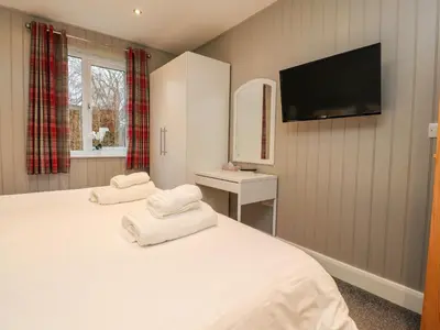 a bedroom with a bed with two towels on it at Holly Lodge in Preston
