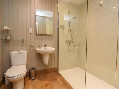 a bathroom with a toilet and a shower and a sink at Holly Lodge in Preston