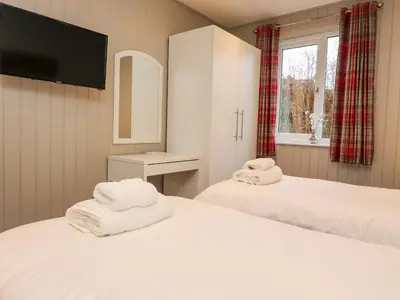 two beds with towels on them in a room at Holly Lodge in Preston