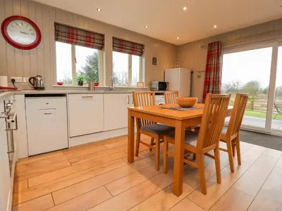 a kitchen with a wooden table and chairs in a kitchen at Holly Lodge in Preston