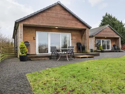 a house with a patio with a table and chairs at Oak Lodge in Preston