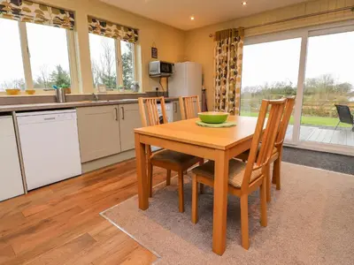 a kitchen and dining room with a wooden table and chairs at Oak Lodge in Preston