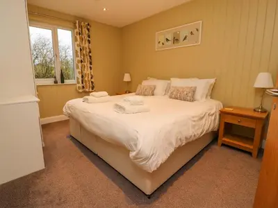 a bedroom with a large bed and a window at Oak Lodge in Preston