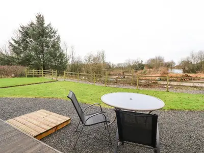 a table and two chairs and a table and a table and a bench at Oak Lodge in Preston