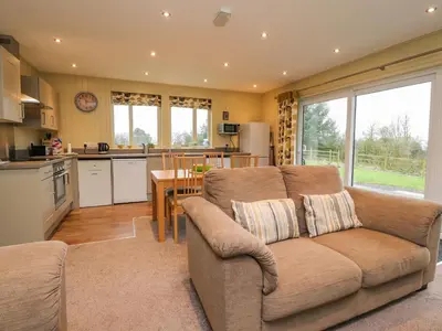 a living room with a couch and a kitchen at Oak Lodge in Preston