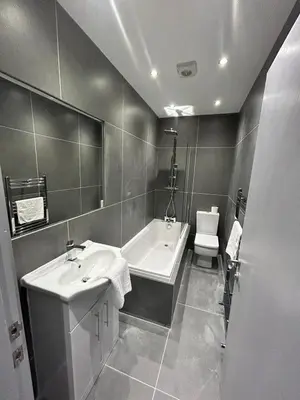 a bathroom with two sinks and a tub and a toilet at Sugar Hill Suite by Sasco Apartments in Blackpool