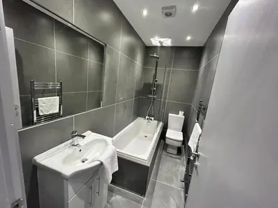 a bathroom with a sink and a tub and a mirror at Sugar Hill Suite by Sasco Apartments in Blackpool