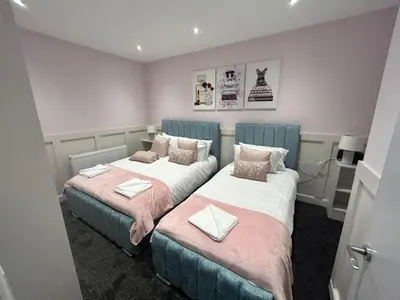 two beds in a small room with pink walls at Sugar Hill Suite by Sasco Apartments in Blackpool