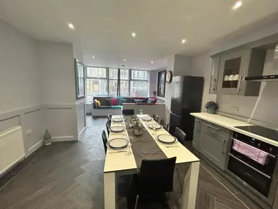 a kitchen with a long table with chairs in it at Sugar Hill Suite by Sasco Apartments in Blackpool