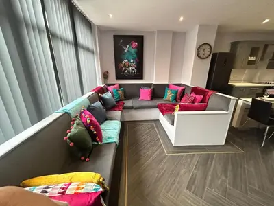 a living room with a couch with colorful pillows at Sugar Hill Suite by Sasco Apartments in Blackpool