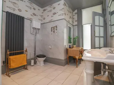 a bathroom with a sink and a toilet and a table at Ismay Billiard Room Apartment - Titanic Interest in Crosby
