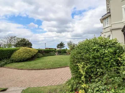 a brick walkway in front of a house with bushes at Ismay Billiard Room Apartment - Titanic Interest in Crosby